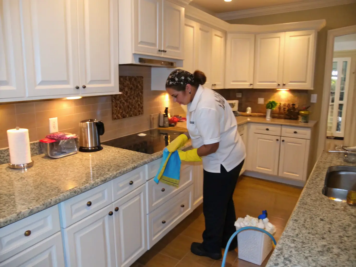 A team of cleaners tidying up a modern apartment kitchen and living space, representing Maviclean's apartment cleaning service.